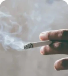 Imagem ilustrativa de uma mão segurando um cigarro aceso.